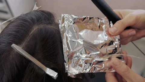 Close-up of the process of highlighting the long brown hair of a girl. The Stock-Footage 155743236