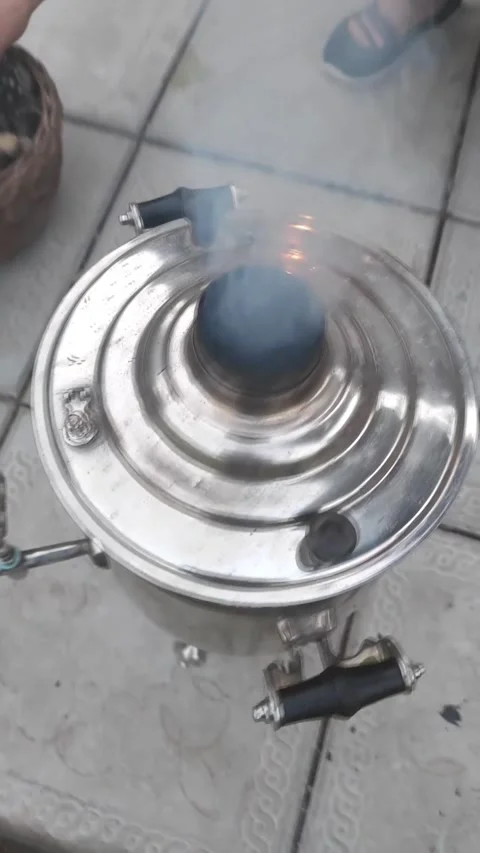 Close up process igniting Russian samovar with dry fir cones,smoke from burner Stock Footage 162232339