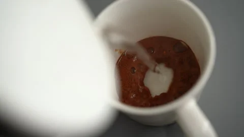 Close-up process making hot instant coffee. Hot water pouring from white kettle 動画素材 342765013