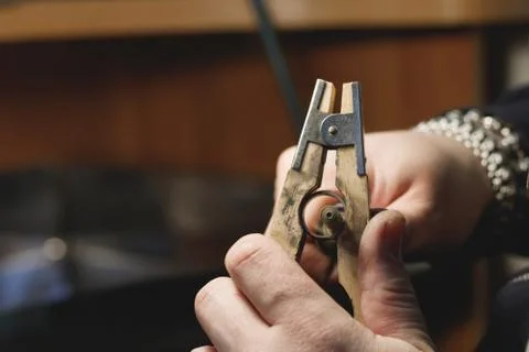 Close-up process of polishing ring made of white gold in a jewelry workshop. Stock Photos