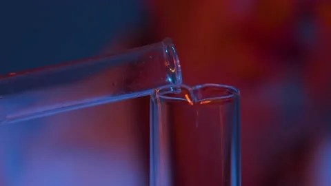 Close-up - the process of pouring green liquid from one test tube into another. Stock Footage 143332437