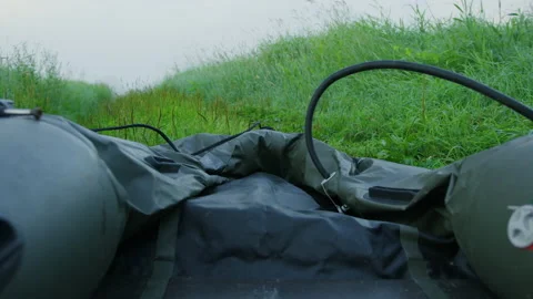 Close-up of the process of pumping an inflatable boat on the grass by the lake Stock Footage 219776947