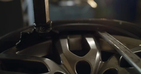Close process of removing a tire from an alloy wheel with a tire changer Stock Footage 128049262