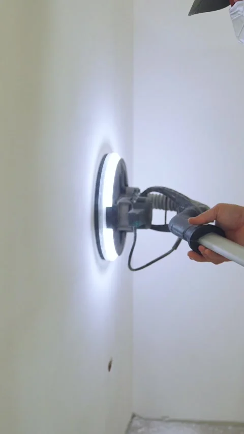 A close-up of the process of sanding walls using a modern sanding machine with Video stock 324047849