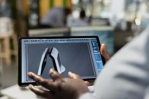 Close up of product designer in office using tablet to create solar gadget Stock Photos