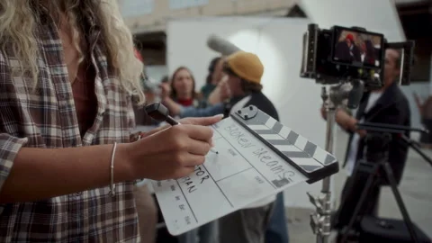 Close Up of Production Assistant Writing Scene Details on Clapperboard 스톡 동영상 336700344