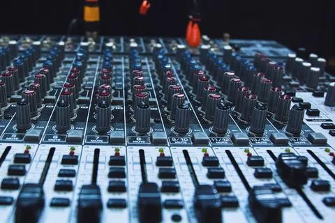 Close up of a professional audio mixing console with many faders and knobs Stock Photos