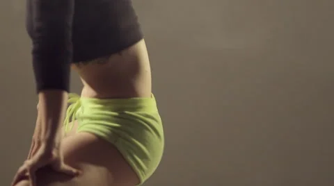 Close-up of professional booty dancer actively moving in the studio on a white Stock Footage 49556569