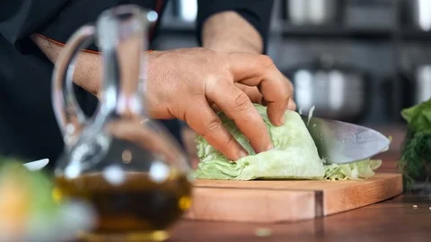 Close-up professional chef hand chopped cabbage on wooden board. Wide shot on Stock Footage 124157855