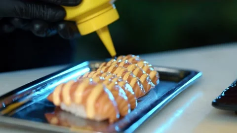 Close up of Professional chef hand decorate salmon sushi roll Stock Footage 239097121