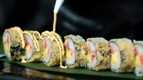 Close up of Professional chef hand decorate salmon sushi roll Stock Footage 239100386