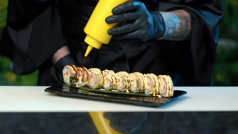 Close up of Professional chef hand decorate salmon sushi roll Stock Footage 239100793
