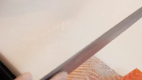 Close-up of professional chef hands slicing fresh raw salmon fillet for sushi an Stock Footage 333489467
