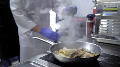 Close-up.A professional chef prepares seafood in the flambe style. Cooking a Stock Footage 167244074