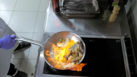 Close-up.A professional chef prepares seafood in the flambe style. Cooking a Stock Footage 167244168