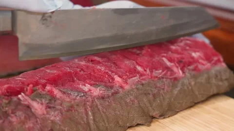 Close-Up of Professional Chef Trimming and Butchering Raw Beef Tenderloin with a Stock Footage 333498563