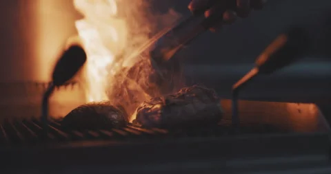 Close up of professional chef using fire grill to cook meat Stock Footage 203556182