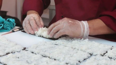 Close-up of professional chef's hands rolling a sushi roll Stock Footage 117342054