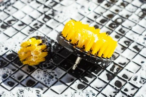 Close up of professional cleaning tools with soapy bubbles on honeycomb mat.  Stock Photos