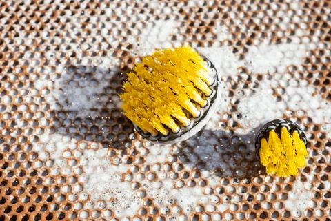 Close up of professional cleaning tools with soapy bubbles on honeycomb mat.  Stock Photos