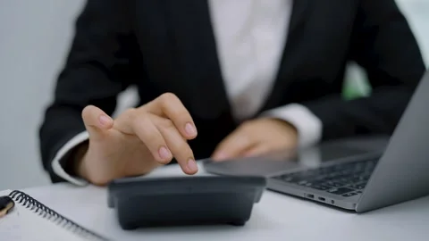Close-up of professional in formal suit using calculator and laptop for fin.. Stock Footage 348486385