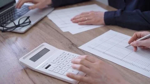 Close up of professional hands using a calculator to conduct financial analysis Stock Photos