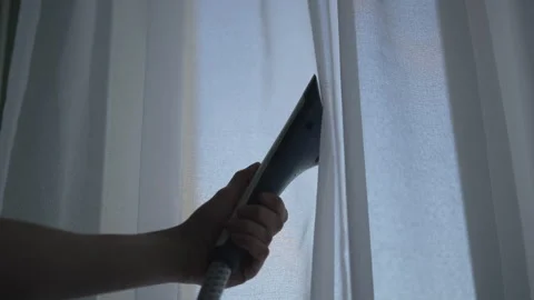 Close-up of professional homemaker using steamer appliance, steaming white Stock Footage 304882141