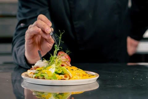 Close up in a professional kitchen chef decorates a vegetable Belgian waffle Stock Photos
