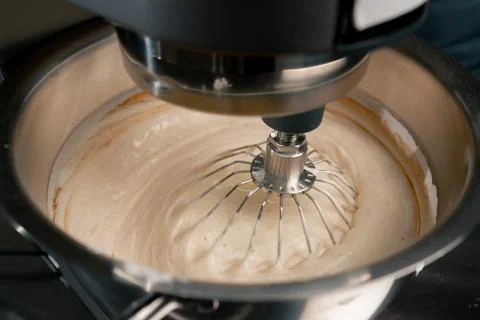 Close-up in a professional kitchen machine beats dough for a cake sweet pastries Stock Photos