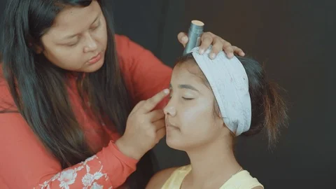 Close up of professional make up artist putting a face powder on woman's Stock Footage 120667712