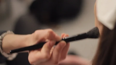 Close-Up of Professional Makeup Artist's Hand with Brush doing Make up on a Stock Footage 93281111