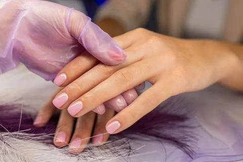 Close up of professional manicure process. Nail technician wearing gloves Stock Photos