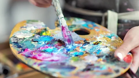 Close-up professional painter hands mixing color paint on palette creating Vídeo Stock 109045307
