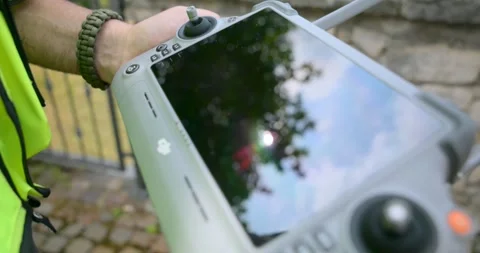 Close-up of professional pilot operating DJI drone smart controller Stock Footage 321733867