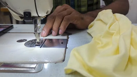 Close-up of professional seamstress hands operating an industrial sewing. Vidéo 333204119
