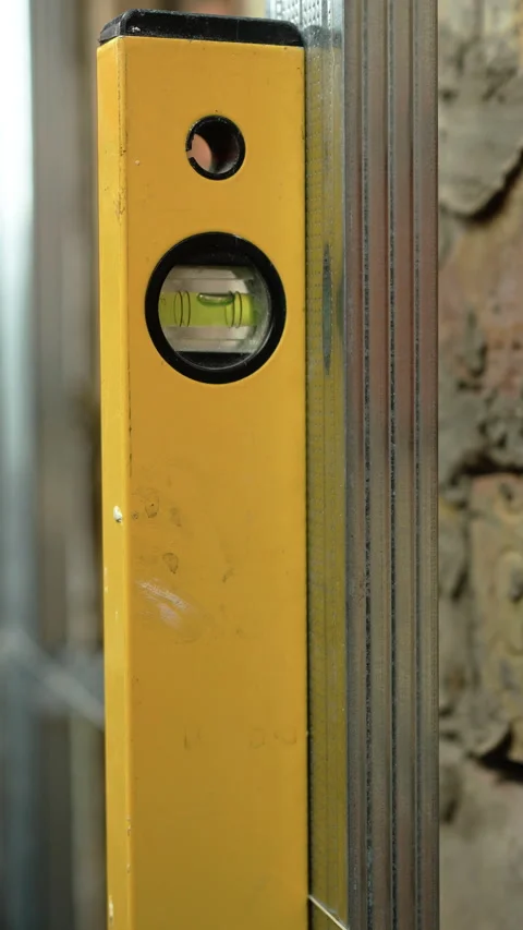 Close up of professional spirit level measuring metal profile for drywall Stock Footage 330356932