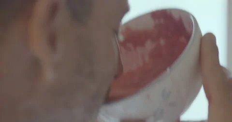 Close up of professional surfer David Langer drinking fresh juice out of bowl Stock Footage 160109894