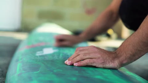 Close up of professional surfer using block of wax on top of surfing board Stock Footage 155790338