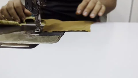 Close-up of Professional Tailor Hand Sewing Fabric with Industrial Machine Stock Footage 333520157
