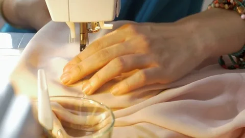 Close-up of professional tailor hands guiding textile in a sewing machine. 動画素材 80472008