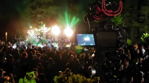 Close-up of a professional video camera capturing footage of a live rock band Stock Footage 278821361