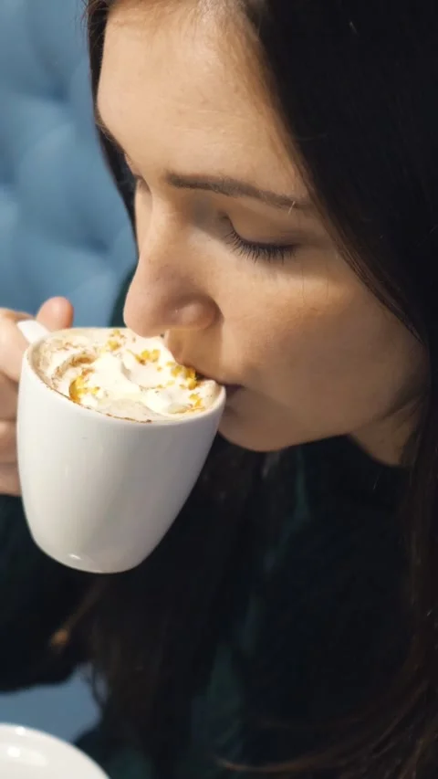 Close up profile of a beautiful young brunette woman smelling and drinking hot Video stock 341678445