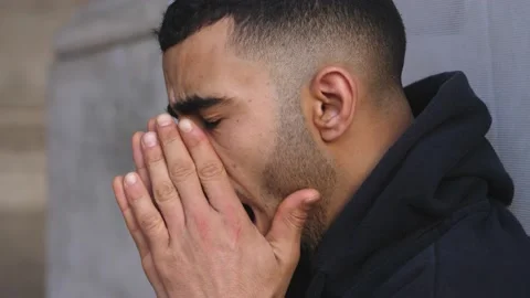 Close up profile of a bored young north african man sitting on the ground 스톡 동영상 218585307
