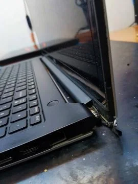 A close up profile of a damaged laptop computer with its screen completely Stock Photos
