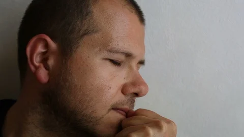 Close-up Profile of a depressed young man closes his eyes, covers his face  Vidéo 114297552