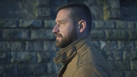 Close profile of man, walking along the wall, steadicam  Vídeo Stock 72775581