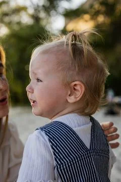 Close-up profile of a toddler with a tiny top knot hairstyle outdoors Stock Photos