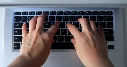 Close up of programmer hands typing code on a laptop keyboard, shown in a Stock Footage 316757391