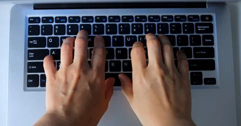 Close up of programmer hands typing code on a laptop keyboard, shown in a Foto stock