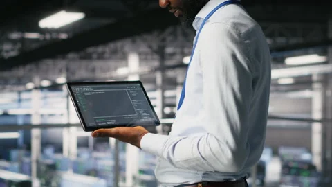 Close up of programmer swiping on tablet display in data center, checking code Video stock 310785437